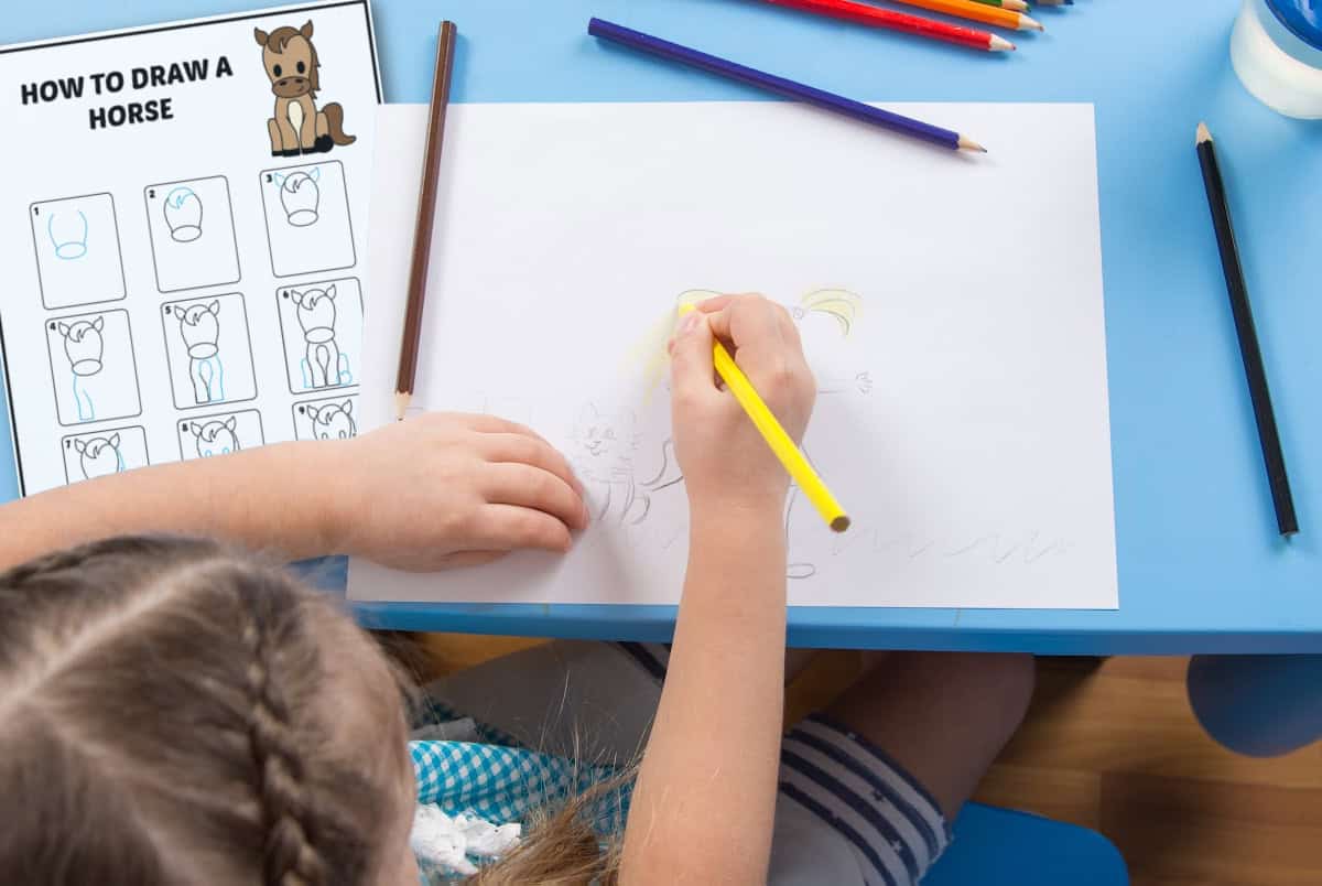 A child sits at a blue table, drawing a horse on white paper with colored pencils. Next to her is a step-by-step guide titled How to Draw a Horse with illustrated drawing instructions.