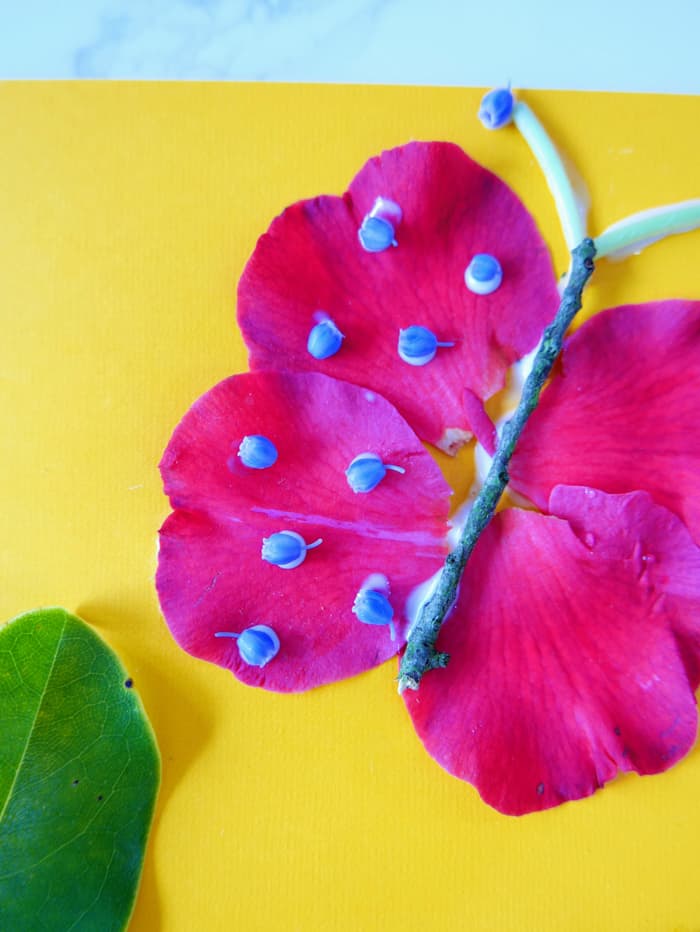 add purple flowers to the top of the butterfly petals