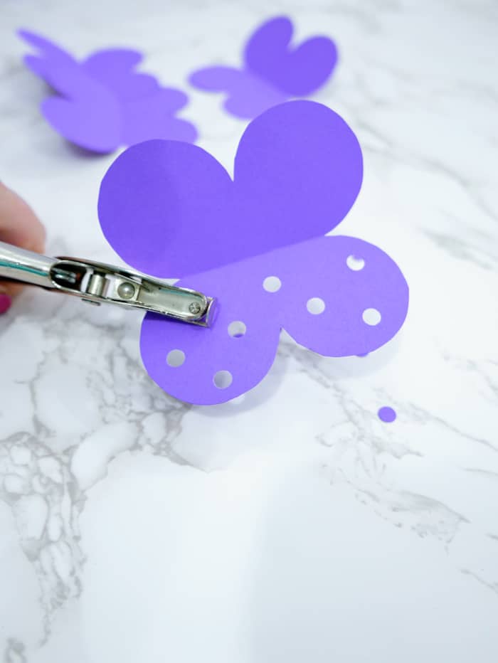 Using a hole punch, make multiple holes in each of the butterfly wings.