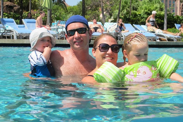 family smiling in a pool at Atlantis Bahamas