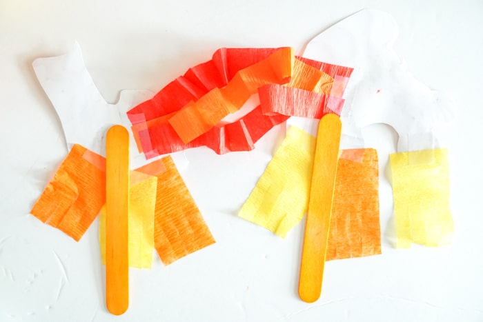 attach popsicle sticks to back of both head and tail of dragon