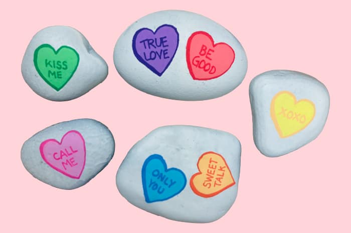 heart rocks outlined in darker color and sayings written in between.