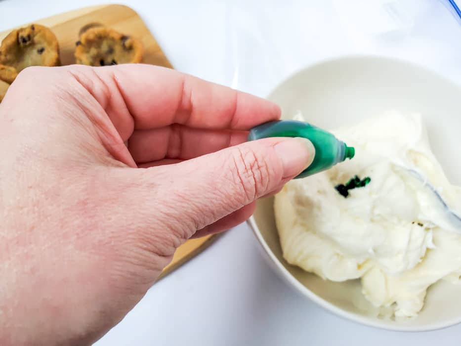 adding green food coloring to white frosting