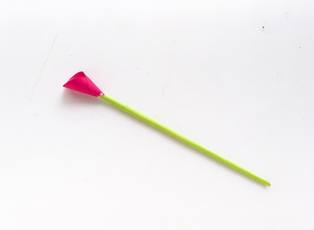 glue flower petal on green paper stick