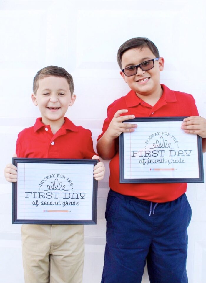 boys holding first day of school signs