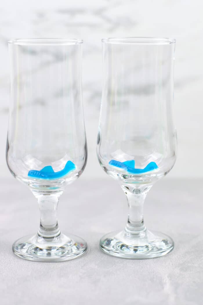 two gummy sharks at the bottom of two glasses