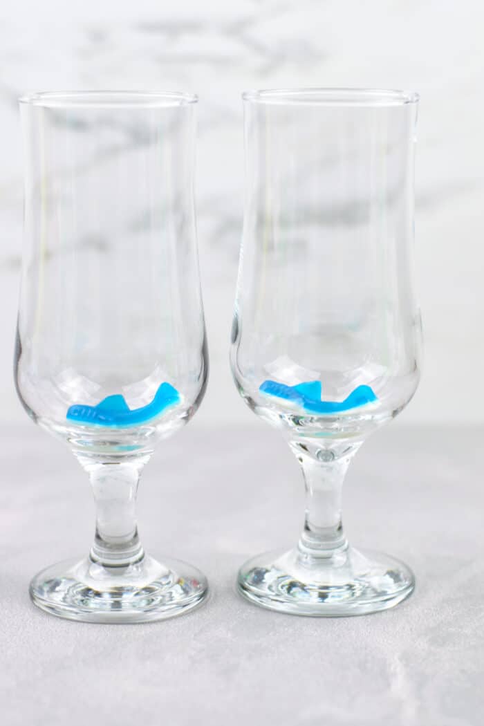 two gummy sharks at the bottom of two glasses