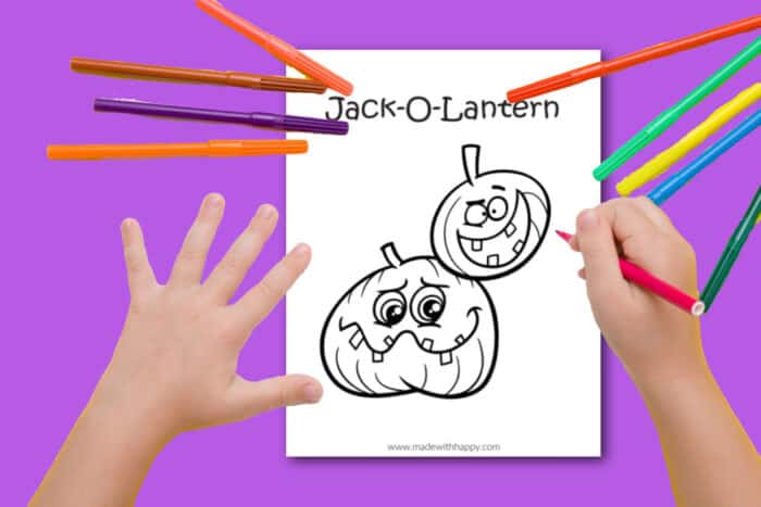 Child coloring a Jack-o-lantern coloring page