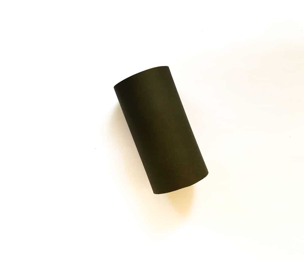 Wrap the toilet paper roll with the black rectangular craft paper.
