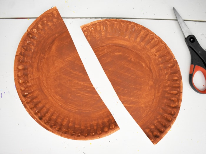 Cut brown paper plate in half