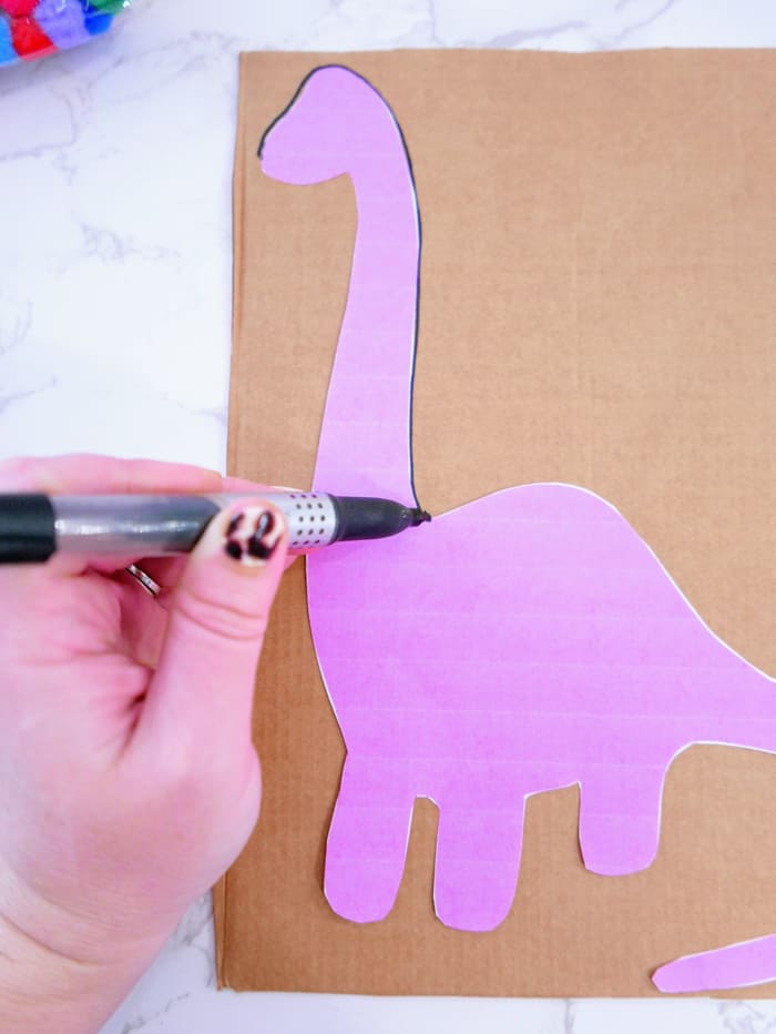 tracing dinosaur template on cardboard