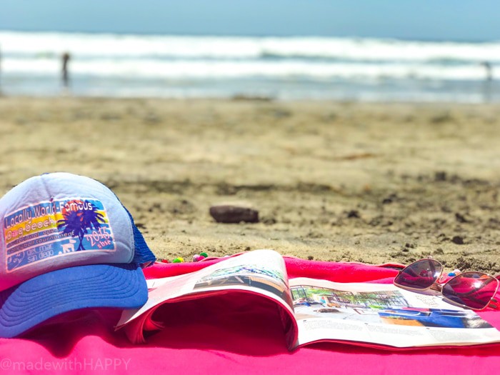 magazine and hat on beach blanket