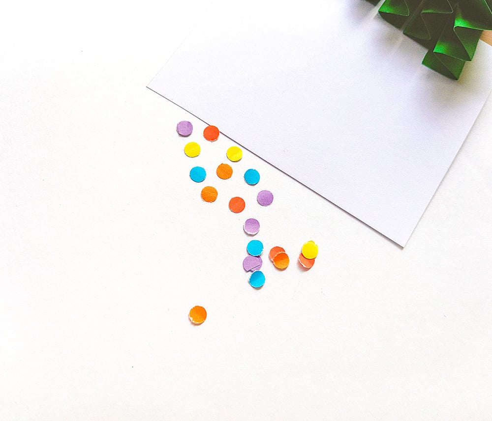 Decorate the card with colourful punched papers.
