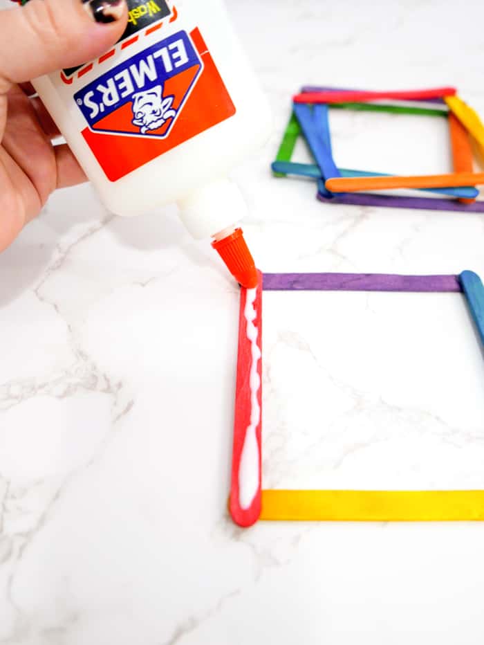 Place glue along each of the sticks on one side.