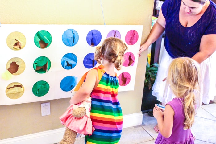 Girl punching rainbow pinata