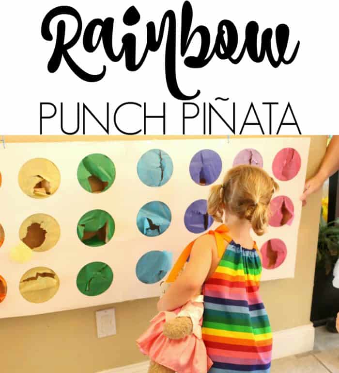 Child playing with rainbow punch pinata at rainbow party