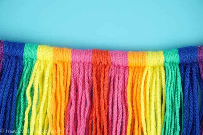 DIY Yarn Wall Hang Tapestry Tutorial. Simple Rainbow Macrame. Colorful Yarn Wall Hanging Tapestry Tutorial. www.madewithhappy.com