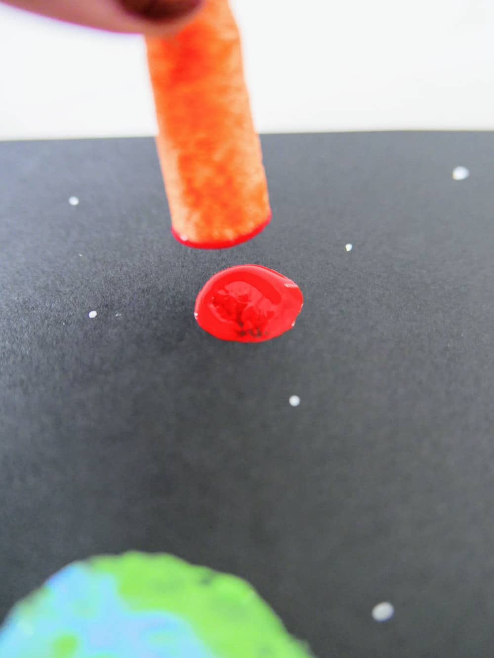 small piece of carrot in red paint