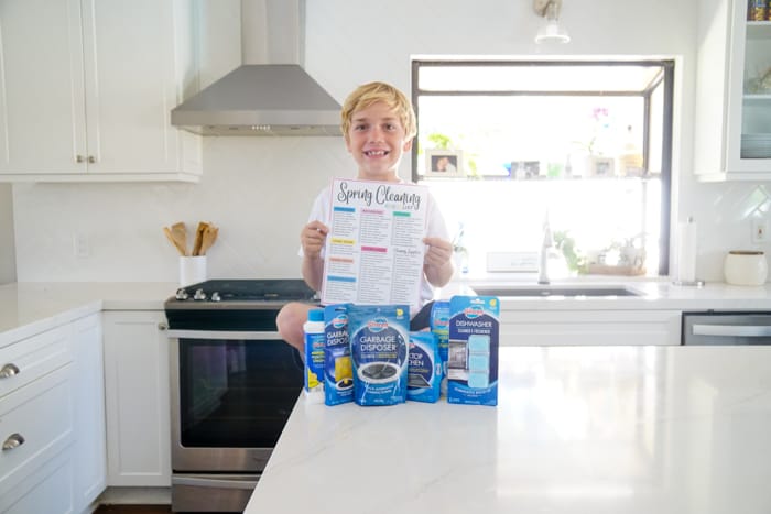 Child on Counter with Cleaning Supplies and Spring Checklist