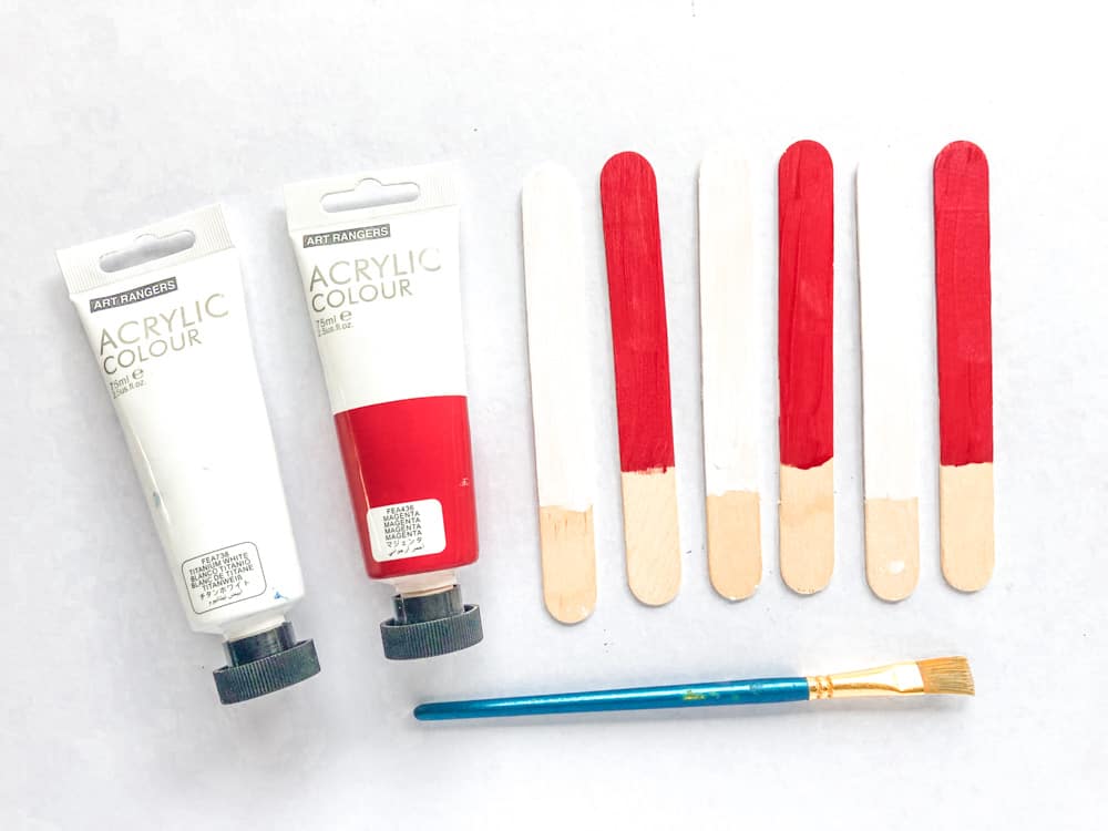 Paint the popsicle sticks red and white