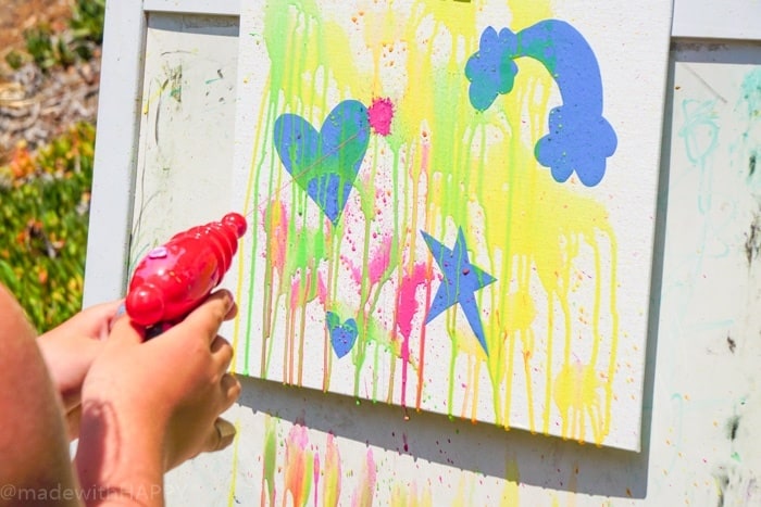 Painting with a water gun. Water gun painting. Looking for Summer activities for the kids? The kids LOVE water gun painting throughout the Summer.