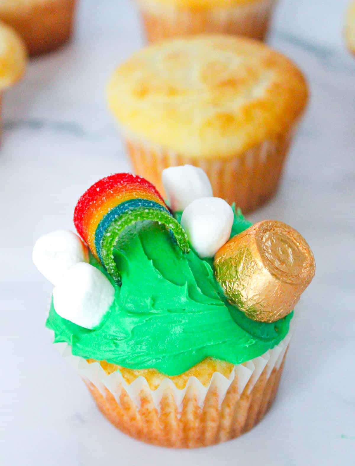 add mini marshmallows and gold rolo to green cupcake
