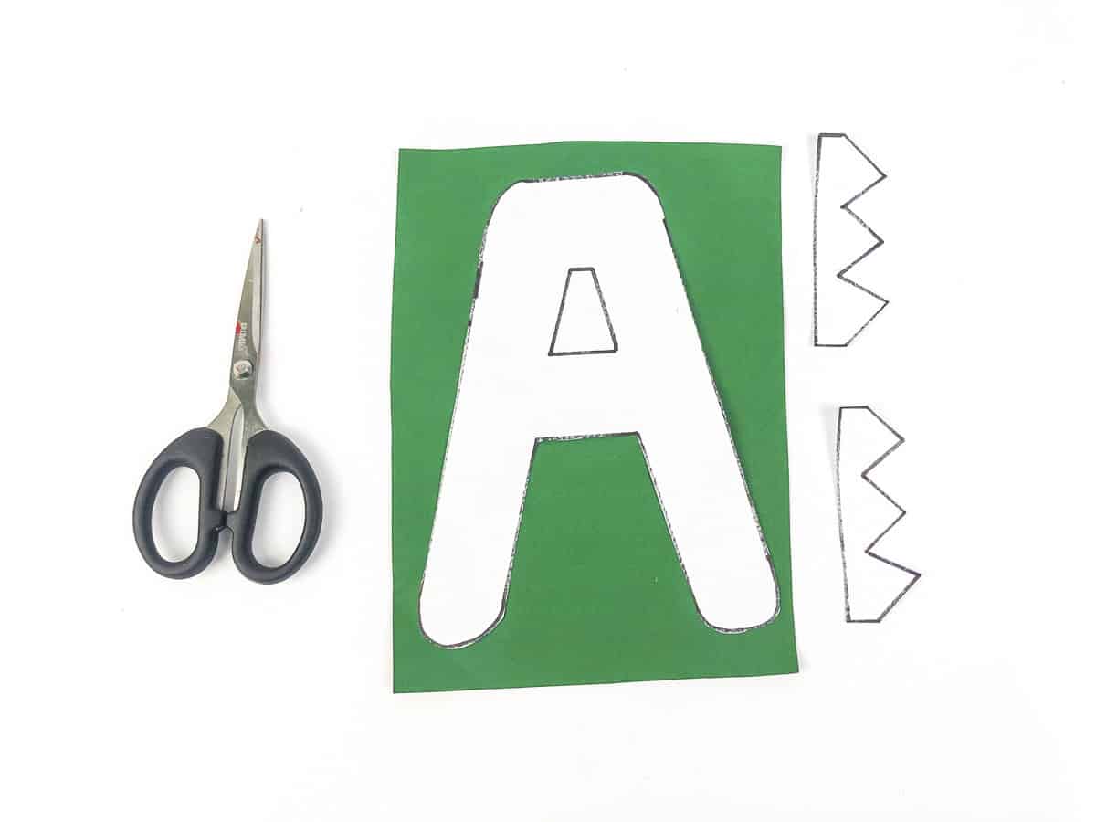 cut a template out of green paper and alligator teeth out of white paper