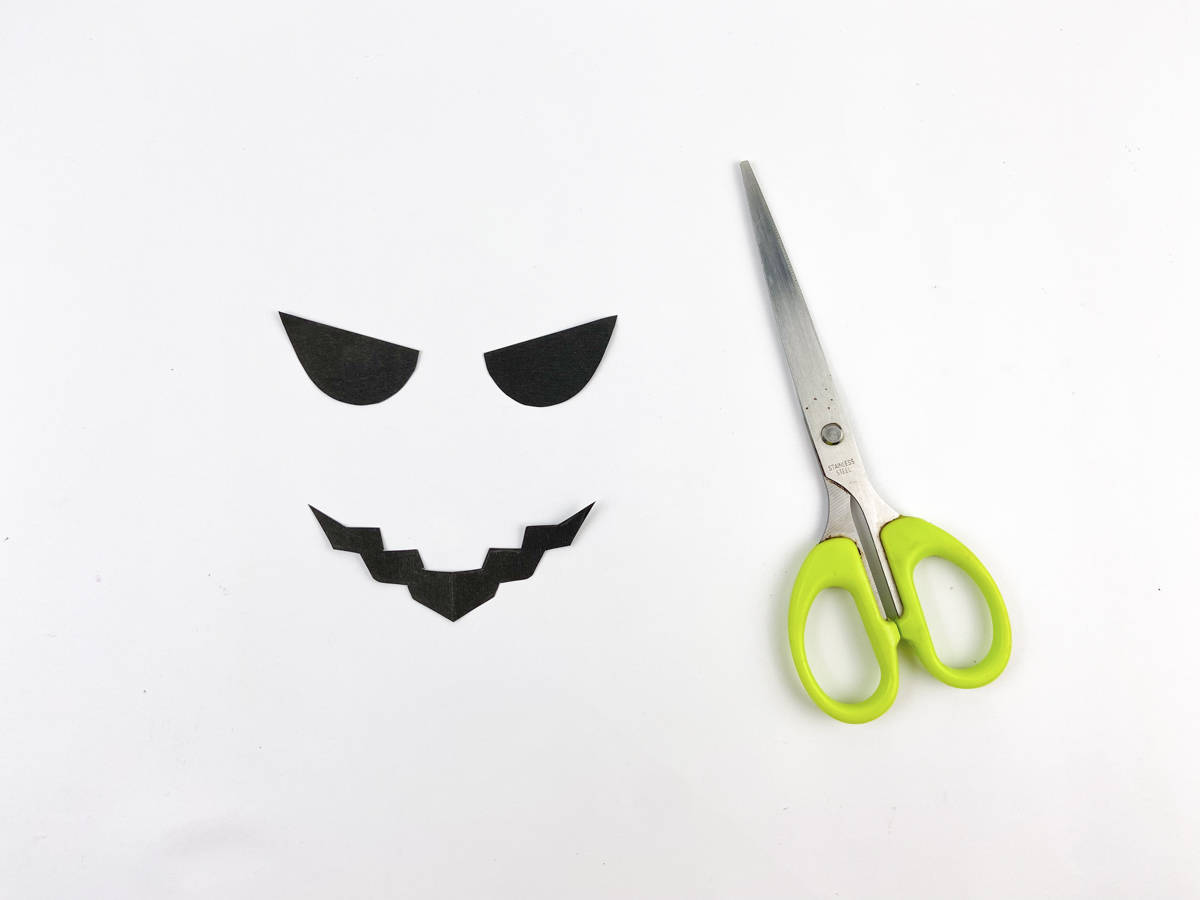 cut pumpkin face template out of black paper