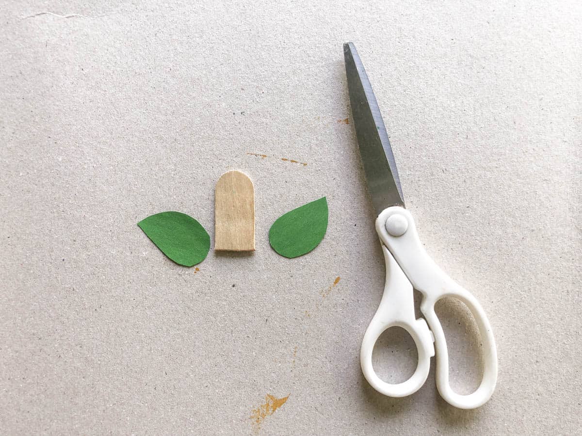 cut tip off popsicle stick and two green leaves for pumpkin craft