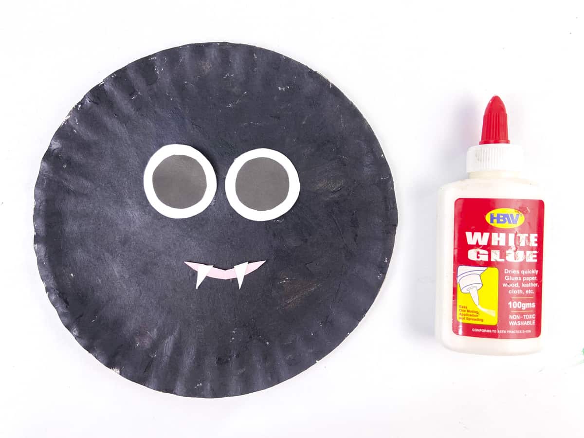 glue bat eyes to paper plate as well as smile and teeth