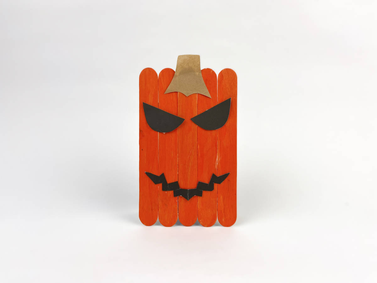 glue face and stem on front of popsicle stick pumpkin