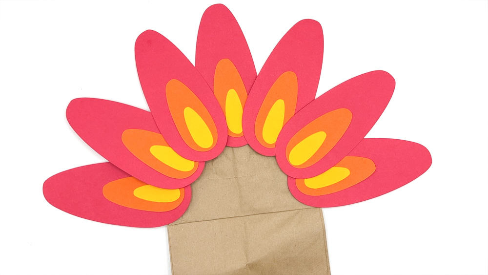 glue feathers to paper bag turkey