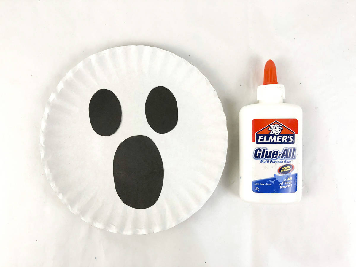 glue ghost face to paper plate