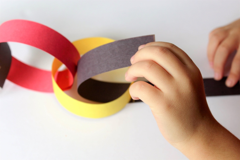 child making paper link chain for Disney countdown activity