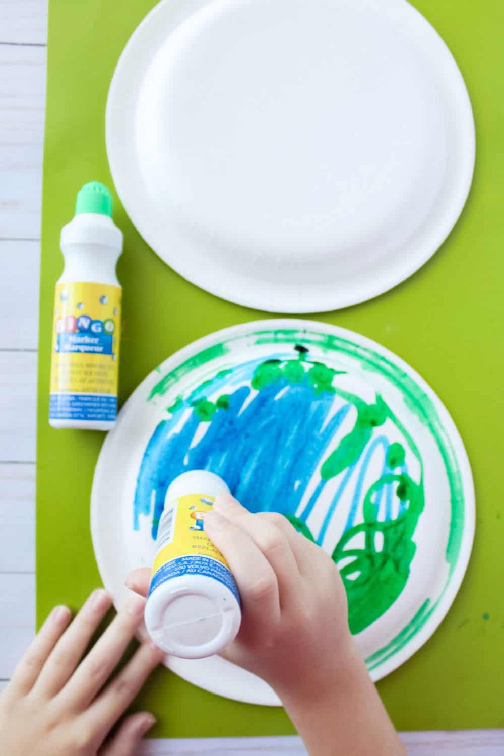 kid painting paper plate like earth