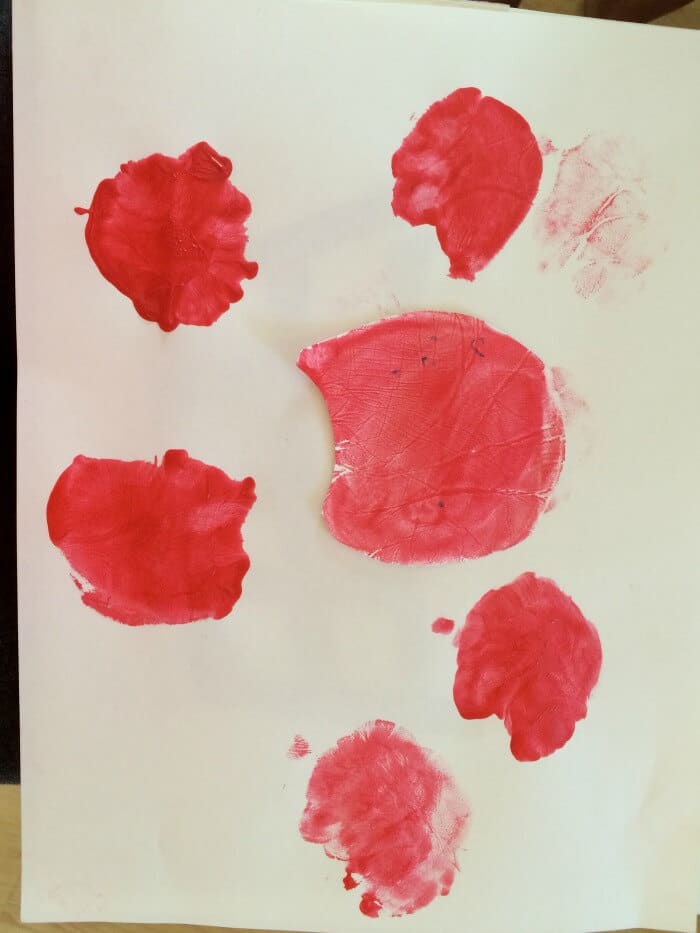 Red hand prints on piece of paper