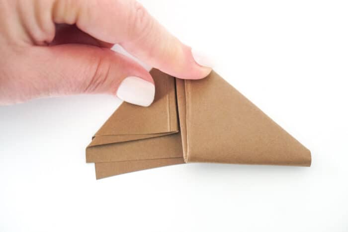 fold left paper tail into a triangle towards football shape