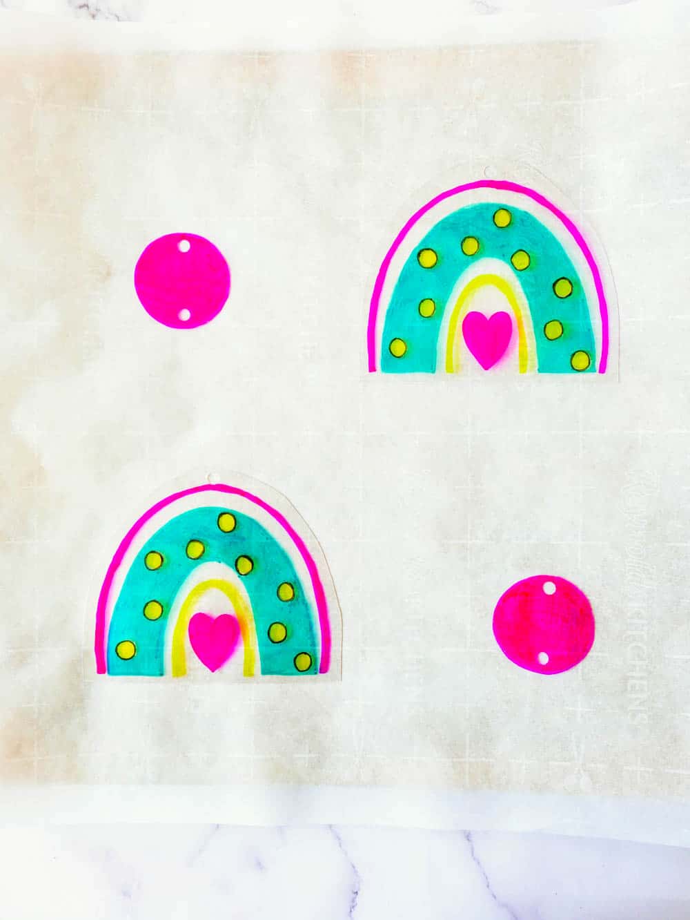 place rainbow earrings on parchment paper