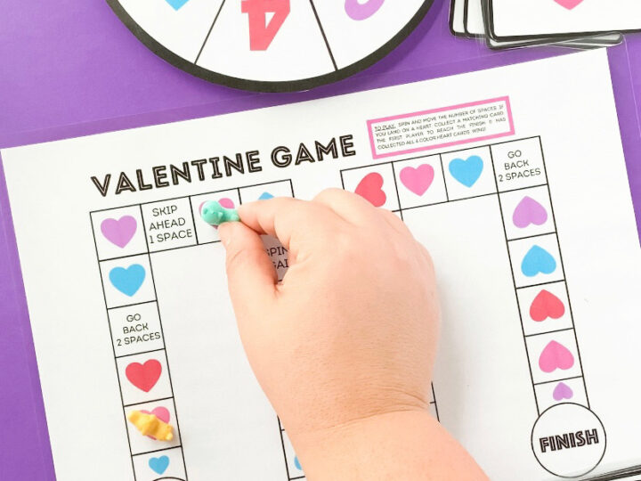 child's hand playing valentine board game