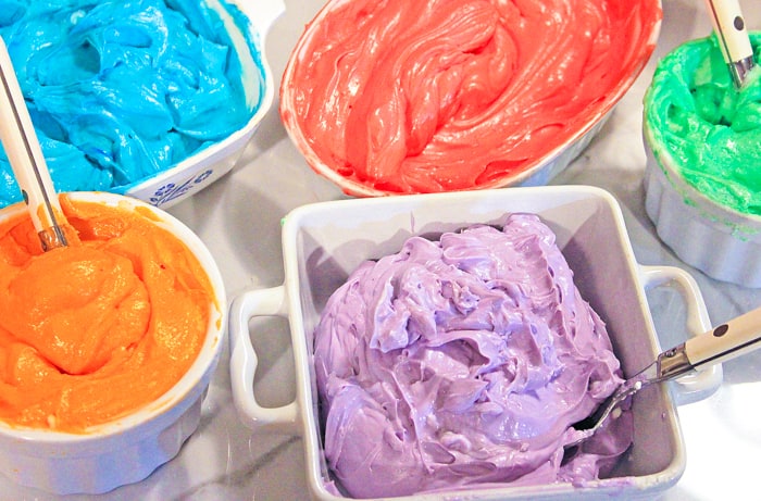 bowls of different colors of cheesecake filling